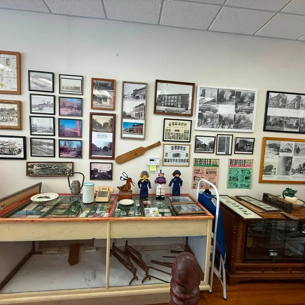 Historic photographs, household objects, and local artifacts displayed inside the Redfield Historical Museum