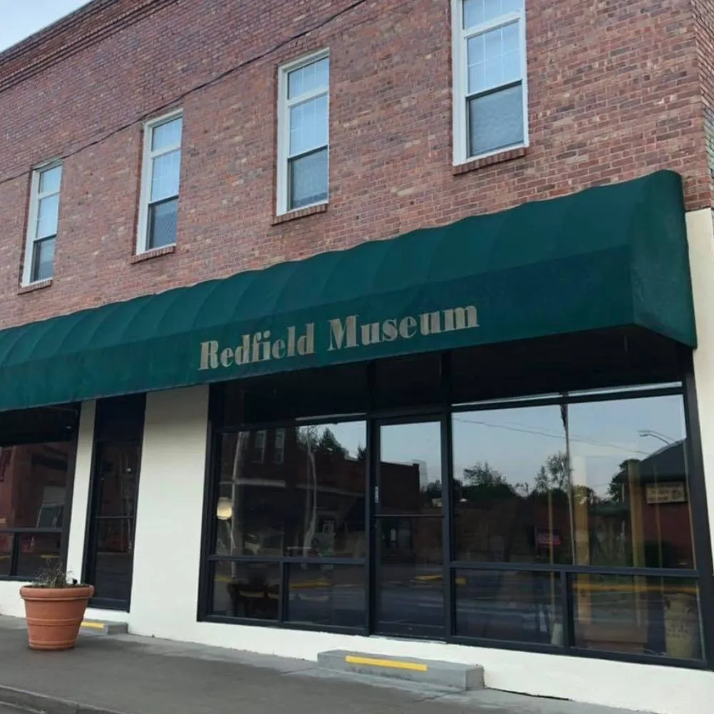 Brick storefront and green awning at the Redfield Historical Museum on First Street