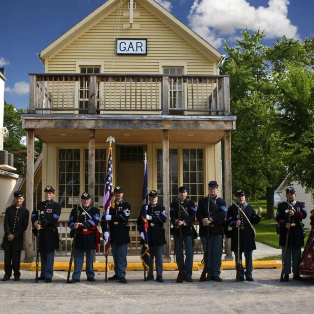 Civil War reenactors standing with flags in front of Redfield's Grand Army of the Republic Lodge