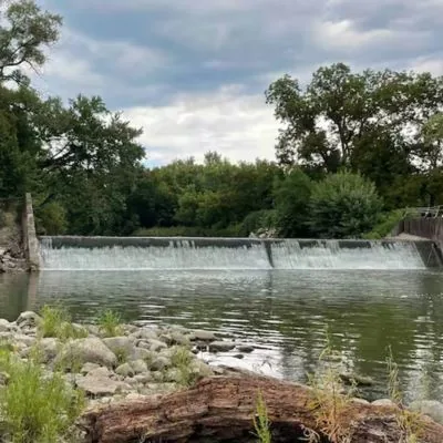 Redfield Dam viewed across the Middle Raccoon River from the rocky riverbank
