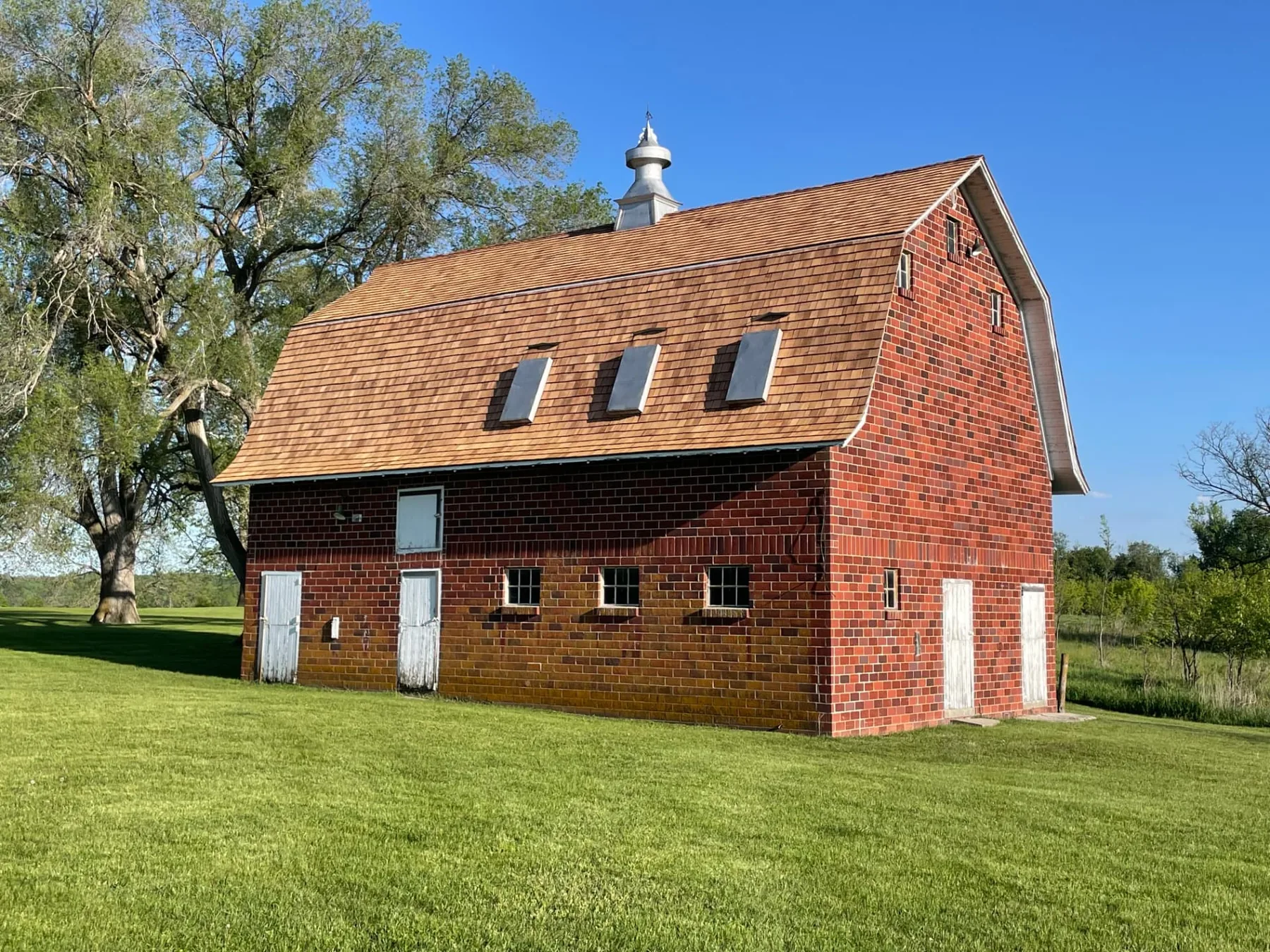 Restored red brick Tile Barn with a new cedar shake roof at Hanging Rock Park