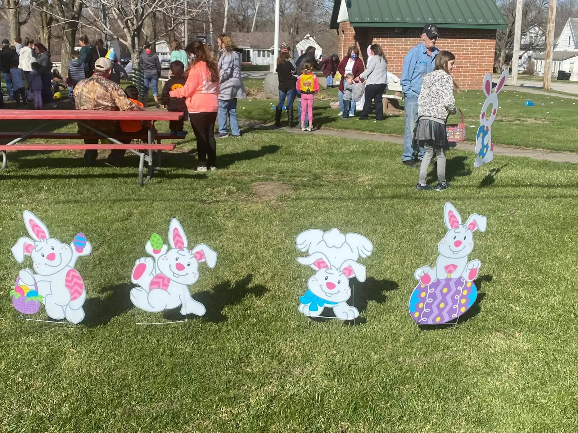 Cheerful Easter bunny yard decorations on the grass as families gather at the egg hunt