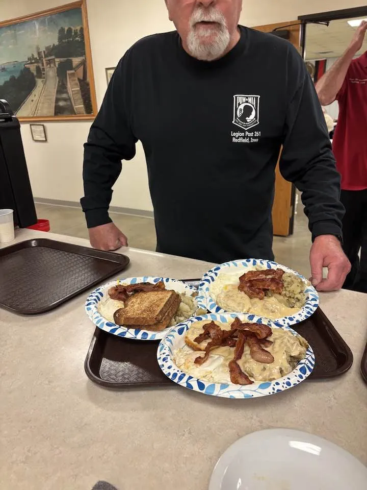 Plates of biscuits and gravy, eggs, bacon, and toast served on a tray at the Legion Saturday breakfast