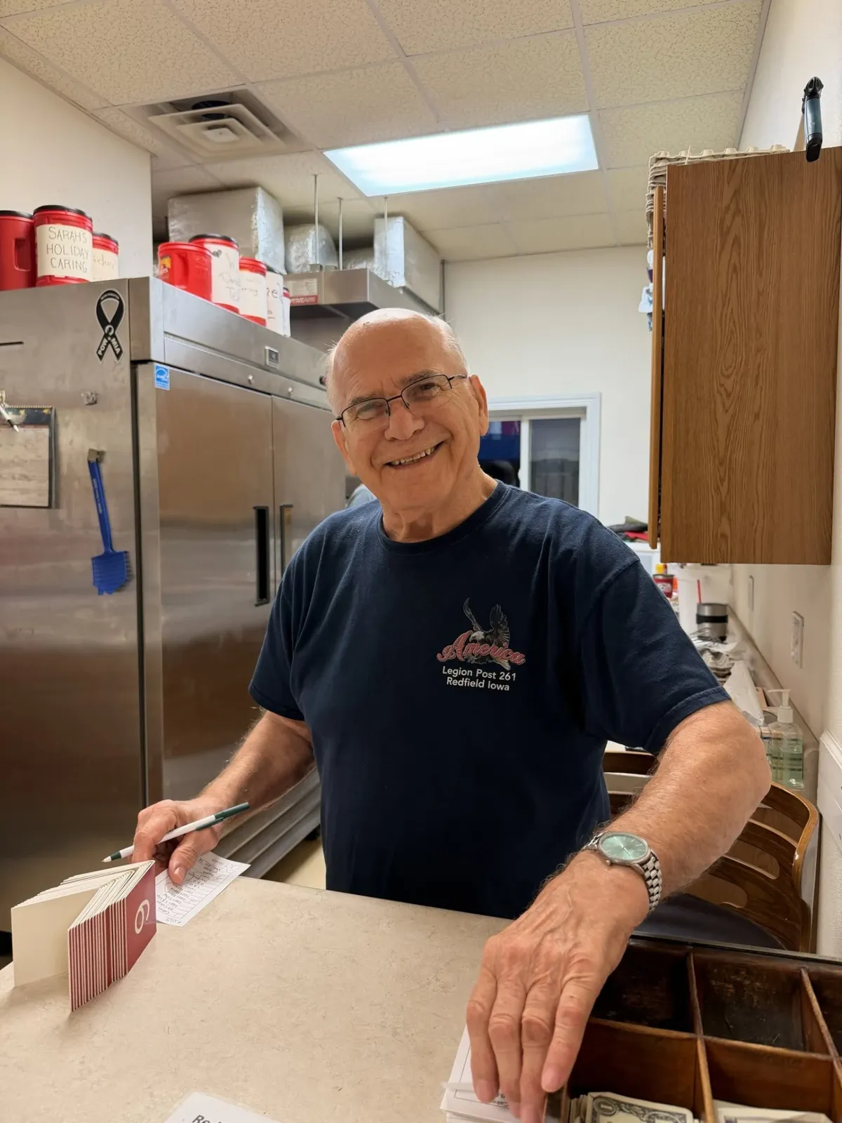 Smiling Legion Post 261 volunteer taking breakfast orders at the counter