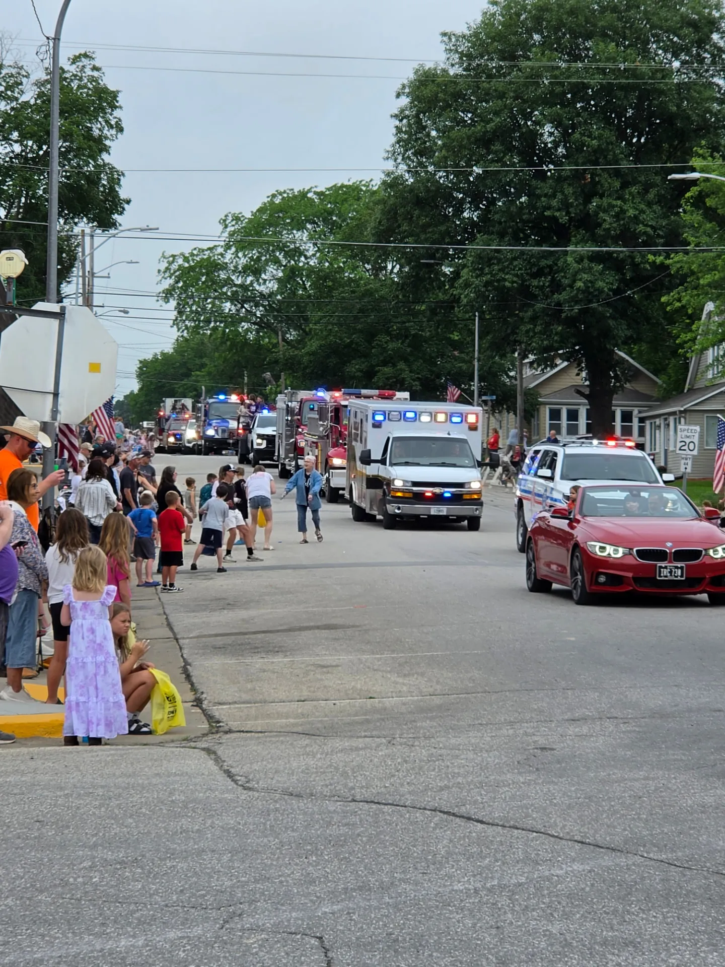 Fire trucks, ambulances, and emergency vehicles rolling down First Street in the Redfield parade